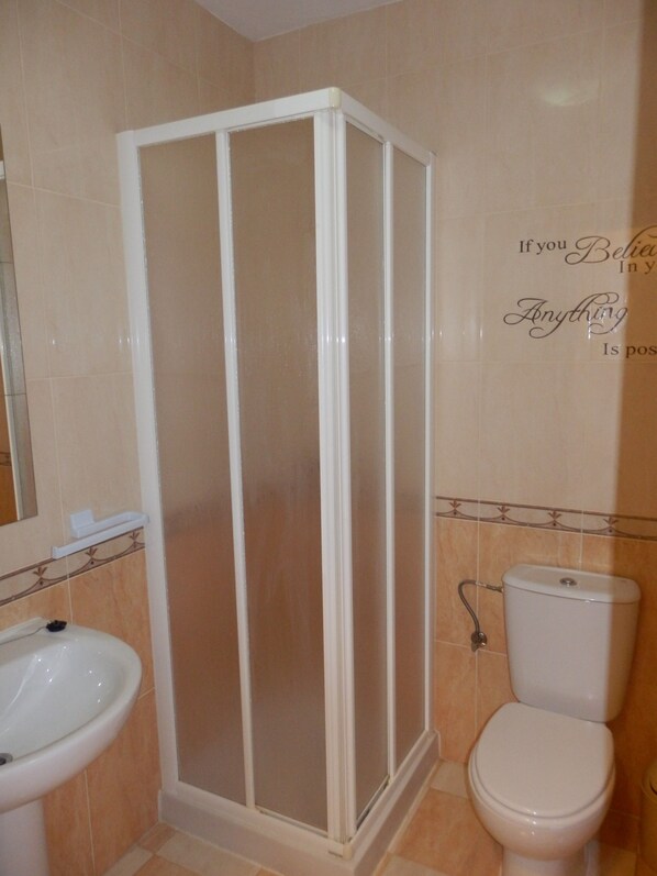 A bathroom with a shower enclosure, a toilet, and a sink. - LOVE NEST IN CUENCA (Arcas)