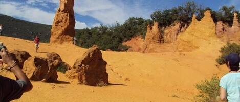 A desert landscape with prominent rock formations and a clear sky.