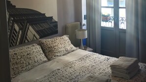 A hotel room with a bed, a radiator, a window with curtains, and a unique ceiling light fixture. - Apartment/ flat -  city center - private parking included (Torino)