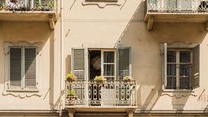 A building facade with a balcony, shutters, and a window with a curtain. - Apartment/ flat -  city center - private parking included (Torino)