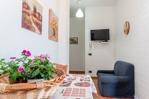 Relax in a cozy living area with a comfortable sofa, flat-screen TV, and decorative wall piece.