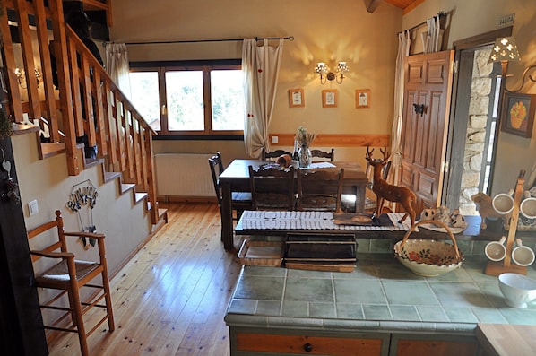 Une cuisine rustique avec un plancher en bois, une table à manger et un escalier.