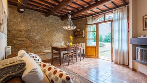 Un comedor rústico con pared de piedra, techo de madera y una mesa lista para dos.