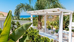 Une pergola blanche avec vue sur l’océan.