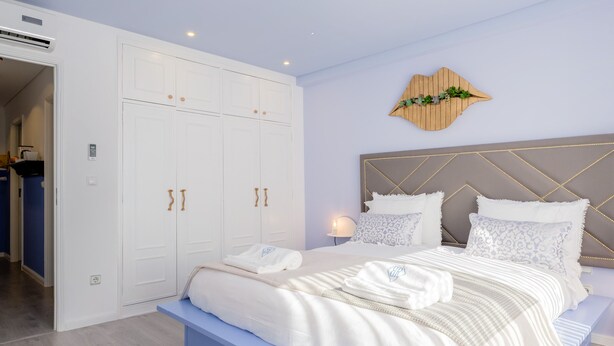 Un dormitorio con una cama grande, un armario y una mesita de noche.
