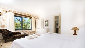 A bedroom with a large bed, a sofa, a dresser, and a window with curtains. - Luxury Kalkan Villa With 2 Pools and Guest House Perfect for Friends or Families (Kalkan)