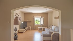 Ein modernes Wohnzimmer mit einer Couch, einem Fernseher und Dekorationselementen.