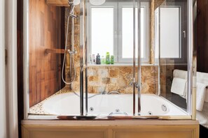 Een bad/douchecombinatie, een bubbelbad,  milieuvriendelijk toiletgerief
