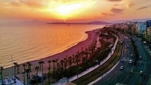 A coastal road with a beach on one side and a cityscape on the other. - ARTISTIC VILLA  LUXURY-with lift, 8-12 people,  Acropolis view, 650m to beach (Palaio Faliro)