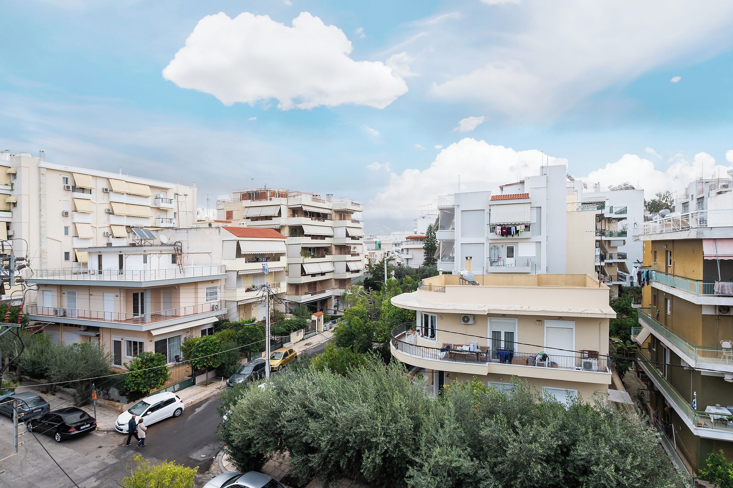 Zona residencial com edifícios altos, varandas e céu claro.