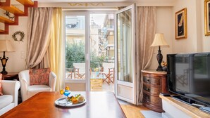 A modern living room with a wooden dining table, a TV, and a balcony with a view of the city. - ARTISTIC VILLA  LUXURY-with lift, 8-12 people,  Acropolis view, 650m to beach (Palaio Faliro)