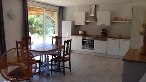 A modern kitchen with white cabinets, a wooden dining table, and chairs.