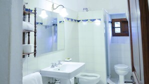 A bathroom with a sink, toilet, and shower.