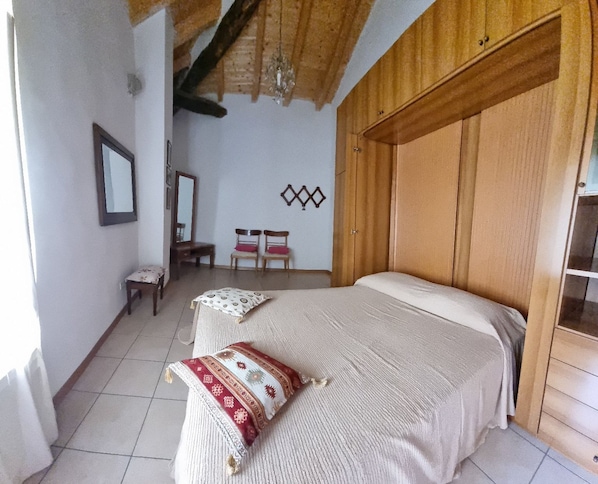 A bedroom with a bed, a chair, a small table, and a mirror. - House with wonderful panoramic terrace overlooking the valley. All inclusive! (Sasseta)
