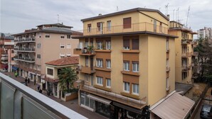 A multi-story residential building with balconies, a ground-level shop, and a parked car. - The apartment is an 8-minute walk from Venice/Mestre ferrrov. station. (Venezia)