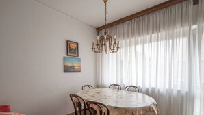 A dining area with a round table, six chairs, a chandelier, and a painting on the wall. - The apartment is an 8-minute walk from Venice/Mestre ferrrov. station. (Venezia)