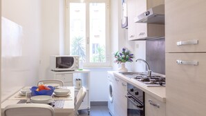 Une cuisine compacte équipée d’un four à micro-ondes, d’un évier, d’une cuisinière et d’un lave-linge.