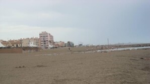 Une plage de sable avec des bâtiments en arrière-plan.
