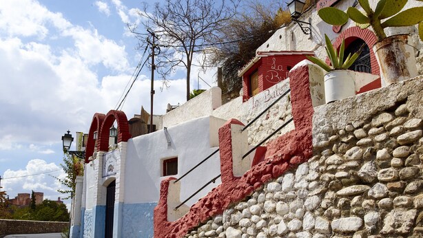 Un bâtiment doté d’un mur en pierre, d’une façade rouge et blanche et d’une enseigne sur laquelle on peut lire « La Batería ».