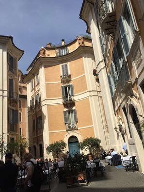 Enjoy meals and drinks in the historic café area with ornate balconies and a central entrance.