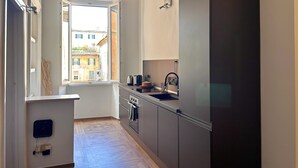 A modern kitchen with a large refrigerator, an oven, and a window with a view of buildings. - Rome: HISTORIC CENTER, close to the Pantheon, Trevi Fountain, Piazza di Spagna. (Roma)