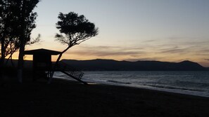 Ein Strand mit einer Holzkonstruktion, möglicherweise einer Rettungswache, mit Blick auf das Meer.