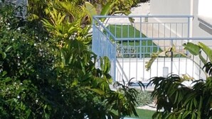 Blick auf ein Wohngebiet mit Pool, Palmen und blauem Himmel.