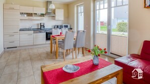 Une cuisine moderne avec un coin repas, un canapé rouge et une vue sur l’extérieur.