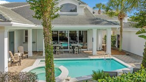 A house with a swimming pool, outdoor furniture, and a covered patio. - Time Out - Destiny East Lux Villa. Pool, Hot Tub, 2 Golf Carts 🛺, 6BR (Destin)