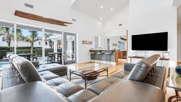 A spacious living area with a pool, a kitchen, and a TV. - Time Out - Destiny East Lux Villa. Pool, Hot Tub, 2 Golf Carts 🛺, 6BR (Destin)