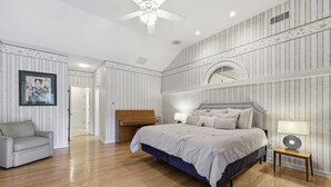 A bedroom with a bed, a chair, a desk, and a ceiling fan. - Beautiful Home, Close to Beach, Lagoon, Fantastic Pool! (Hilton Head Island)