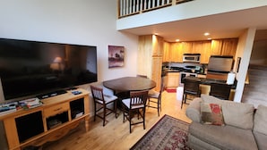 Una sala de estar con televisión, muebles de madera y un sofá.