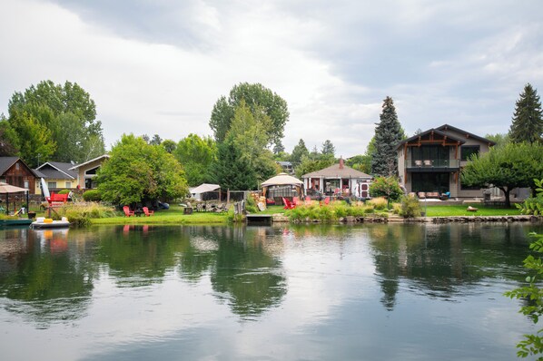 A lakeside property with a dock, boats, and a gazebo.