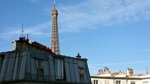 Une vue de la Tour Eiffel avec un bâtiment au premier plan.