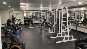 A gym with various exercise equipment, a mirrored wall, and a clock on the wall. - Ski-In, Ski-Out, Corner Unit. Sleeps 4. Hot Tubs, Pool, 65" OLED TV. Near Base (Winter Park)
