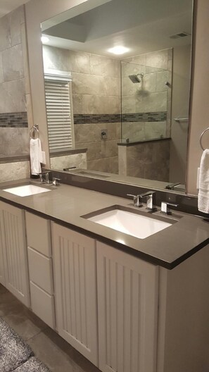 A bathroom with two sinks, a large mirror, and a shower. - Celebrate at the Beach Thanksgiving! Private Pool and Free Bikes! (Hilton Head Island)