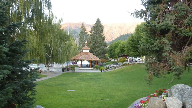A gazebo with a tiled roof surrounded by a well-maintained lawn and flower beds. - Leavenworth Vacation Rental, Luxury , Downtown,  Amazing Mountain View Condo,  (Leavenworth)