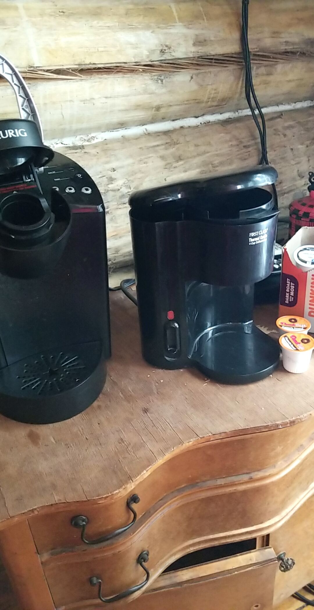 Een koffiezetapparaat en een thermoskan op een houten oppervlak.