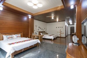 A hotel room with two beds, a wooden ceiling, and a small table with chairs. - Yi Home (Tainan)