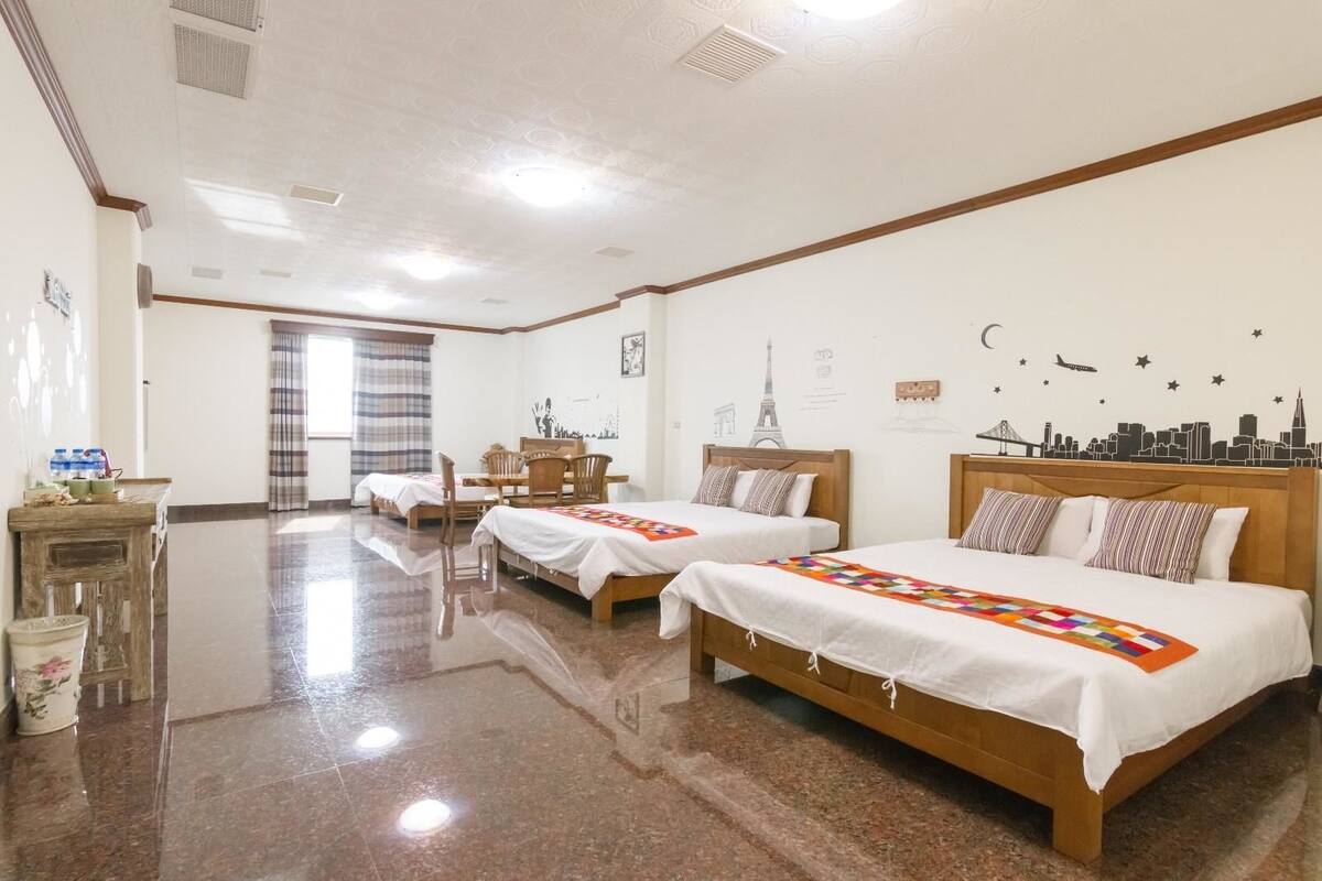 Une chambre d’hôtel avec deux lits, une table à manger et des chaises.