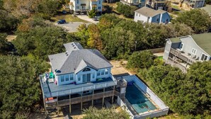 Une propriété résidentielle dotée d’une grande terrasse, d’une piscine et d’un espace extérieur couvert.
