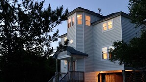 Une maison à deux étages dotée d’un porche et d’une véranda couverte à l’avant.