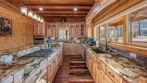 Una cocina amplia con armarios de madera, encimeras de granito y una isla grande.