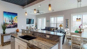 A modern kitchen with granite countertops, a built-in sink, and pendant lighting.