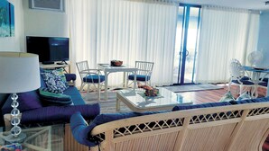 A living room with a sofa, chairs, a coffee table, and a television.