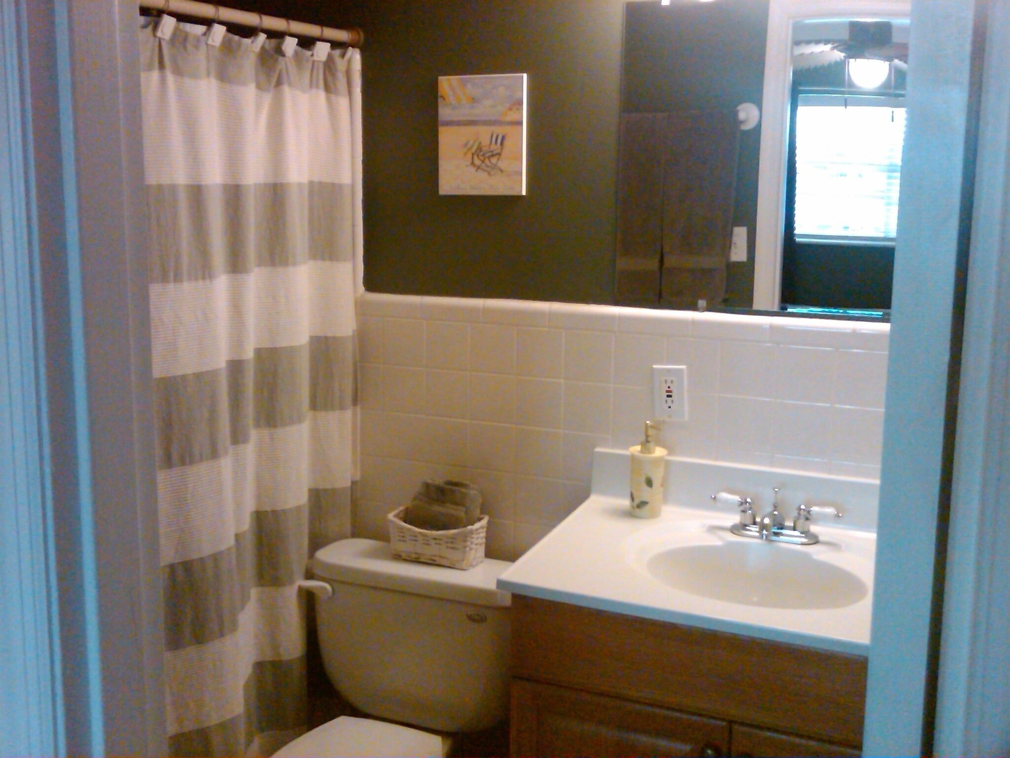 Une salle de bain avec des toilettes, un lavabo et un rideau de douche.