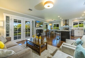 A spacious living area with a kitchen, large sliding glass doors, and a dining area. - CLEAN PRIVATE FAMILY HOME with Pool, Oceanview, Walk to Beach, Lots of Amenities (Kihei)