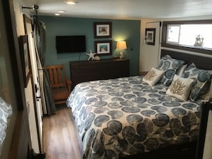 A bedroom with a bed, dresser, and a TV mounted on the wall. - Last minute discounts!Pet friendly with AC steps to beach-SUV parking (San Diego)