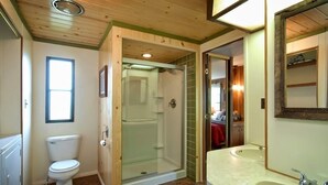 Een badkamer met toilet, douche en wastafel.