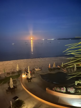 A beachside resort with outdoor seating and a pool area.
